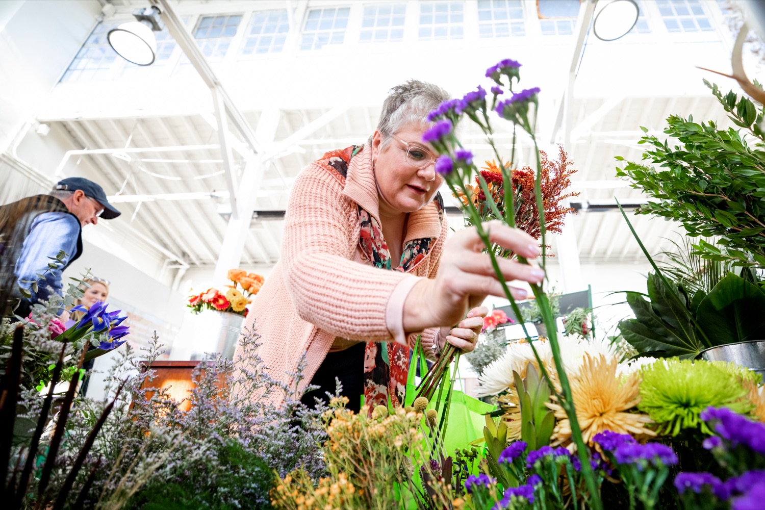 Nina Redding picks out flowers from D. McGee Design Studio while grocery shopping for Thanksgiving inside Broad Street Market on Thursday, November 21, 2019.<br><a href="https://filesource.amperwave.net/commonwealthofpa/photo/17546_AGRIC_Buy_Local_NK_009.JPG" target="_blank">⇣ Download Photo</a>