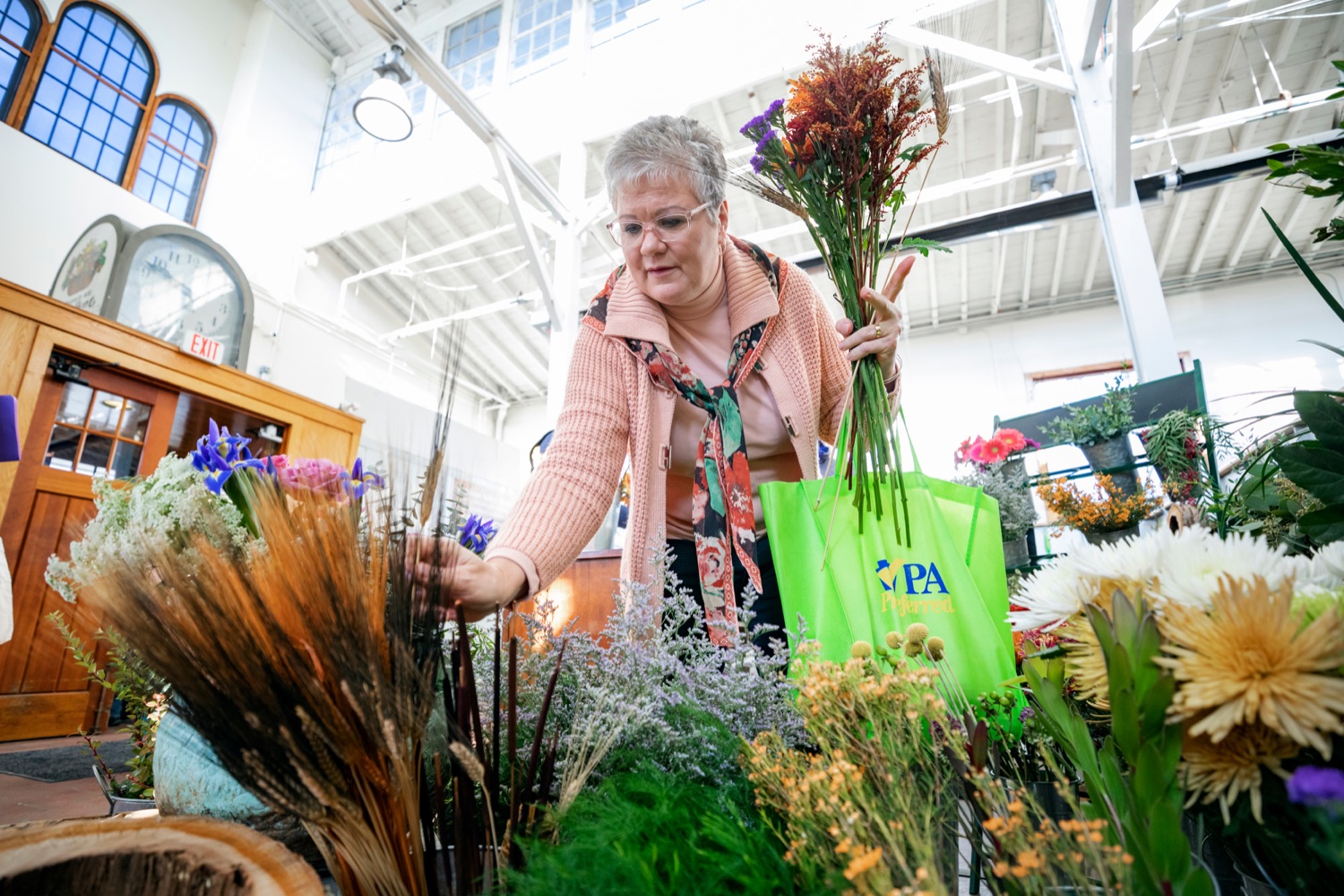 Nina Redding picks out flowers from D. McGee Design Studio while grocery shopping for Thanksgiving inside Broad Street Market on Thursday, November 21, 2019.<br><a href="https://filesource.amperwave.net/commonwealthofpa/photo/17546_AGRIC_Buy_Local_NK_012.JPG" target="_blank">⇣ Download Photo</a>