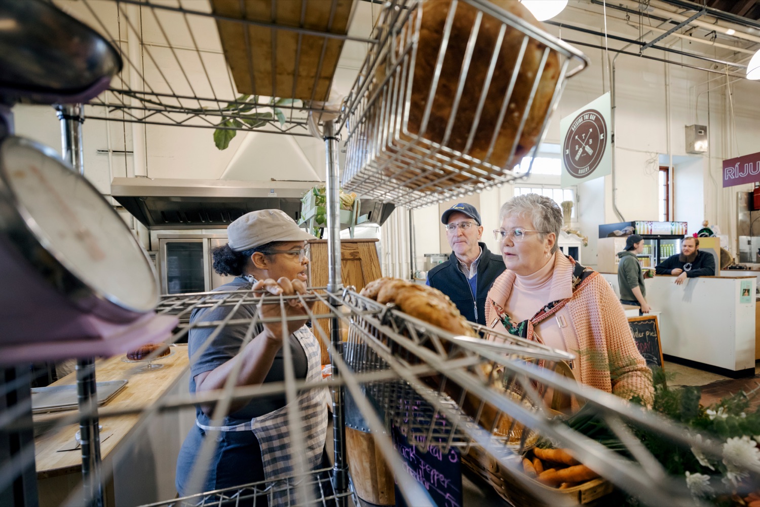 Pennsylvania Department of Agriculture Secretary Russell Redding, center, and wife Nina, pick out fresh bread from Timishia Goodson, co-founder and baker at Raising the Bar, while grocery shopping for Thanksgiving dinner inside Broad Street Market on Thursday, November 21, 2019.<br><a href="https://filesource.amperwave.net/commonwealthofpa/photo/17546_AGRIC_Buy_Local_NK_022.JPG" target="_blank">⇣ Download Photo</a>