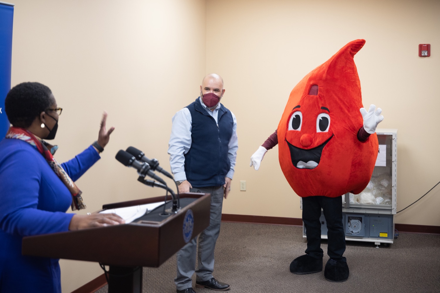 Physician General Dr. Denise A. Johnson greeting the Central Pennsylvania Blood Bank mascot.  Pennsylvania Physician General Dr. Denise Johnson and Patrick Bradley, President and CEO of the Central Pennsylvania Blood Bank, expressed their growing concern over the dramatically decreasing number of volunteers who regularly donate blood, during a news conference highlighting the critical need for blood donation across the commonwealth.  February 03, 2022 - Hummelstown, Pa<br><a href="https://filesource.amperwave.net/commonwealthofpa/photo/20488_doh_bloodShortage_dz_006.jpg" target="_blank">⇣ Download Photo</a>