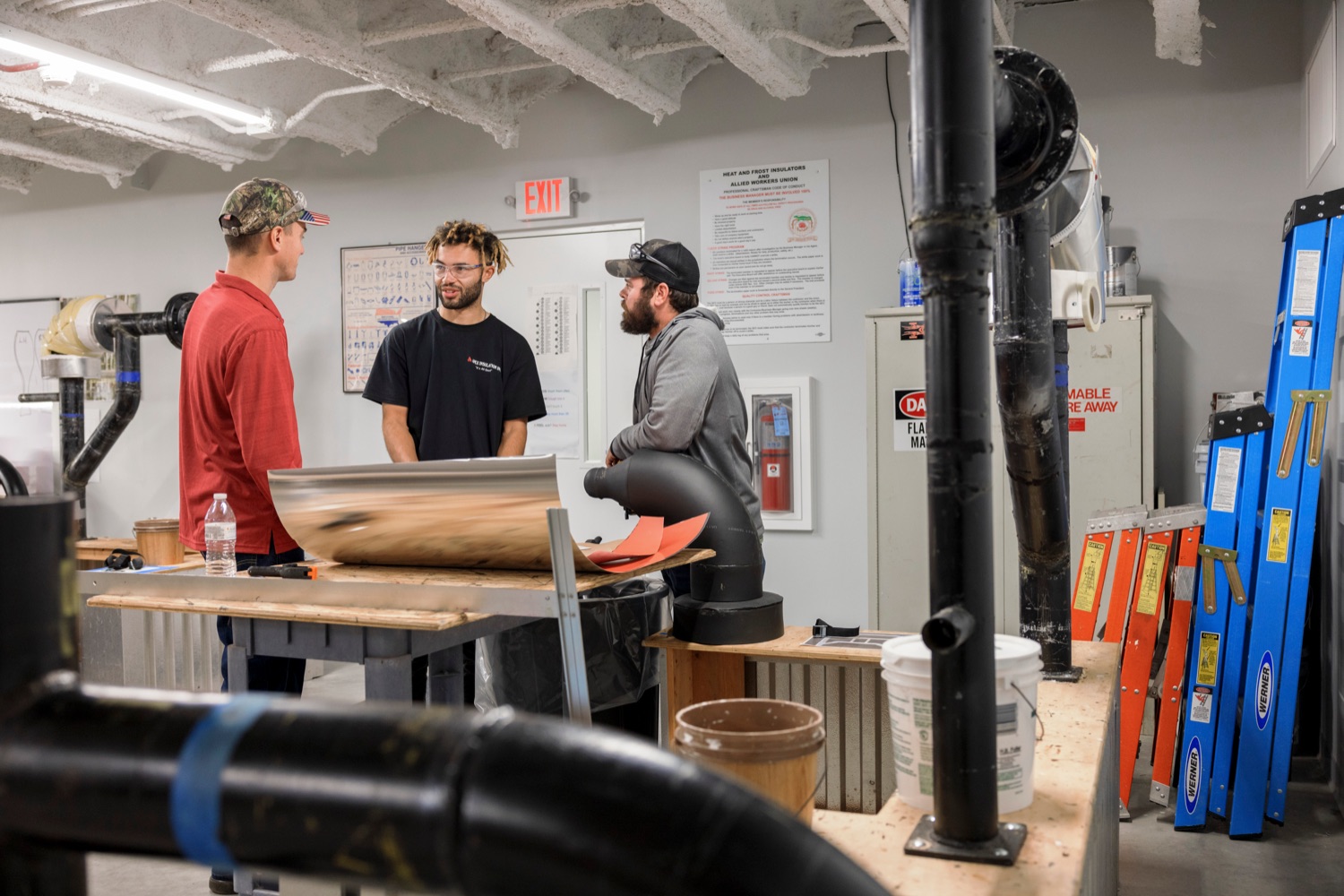 From left; Anthony Ferguson, a part time instructor at Heat and Frost Insulators Local 23; Anthony Riddick, 24, and Josh Schegan, 35, look at layouts for pipe insulation following a press conference which kicked off National Apprenticeship Week with a visit to Heat and Frost Insulators Local 23, a training center in Dauphin County, on Monday, November 14, 2022. National Apprenticeship Week (NAW) is a nationwide celebration for industry, labor, equity, workforce, education and government leaders to showcase the successes and value of registered apprenticeship for building our economy, advancing racial and gender equity, and supporting underserved communities.<br><a href="https://filesource.amperwave.net/commonwealthofpa/photo/22344_li_apprenticeshipweek_NK_004.JPG" target="_blank">⇣ Download Photo</a>